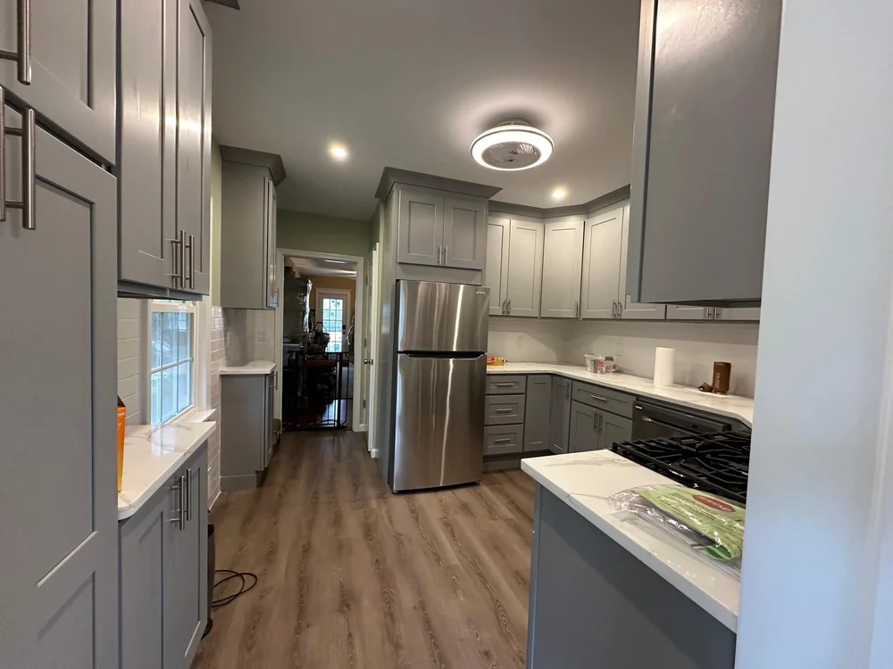 Modern gray galley kitchen with quartz countertops and stainless appliances